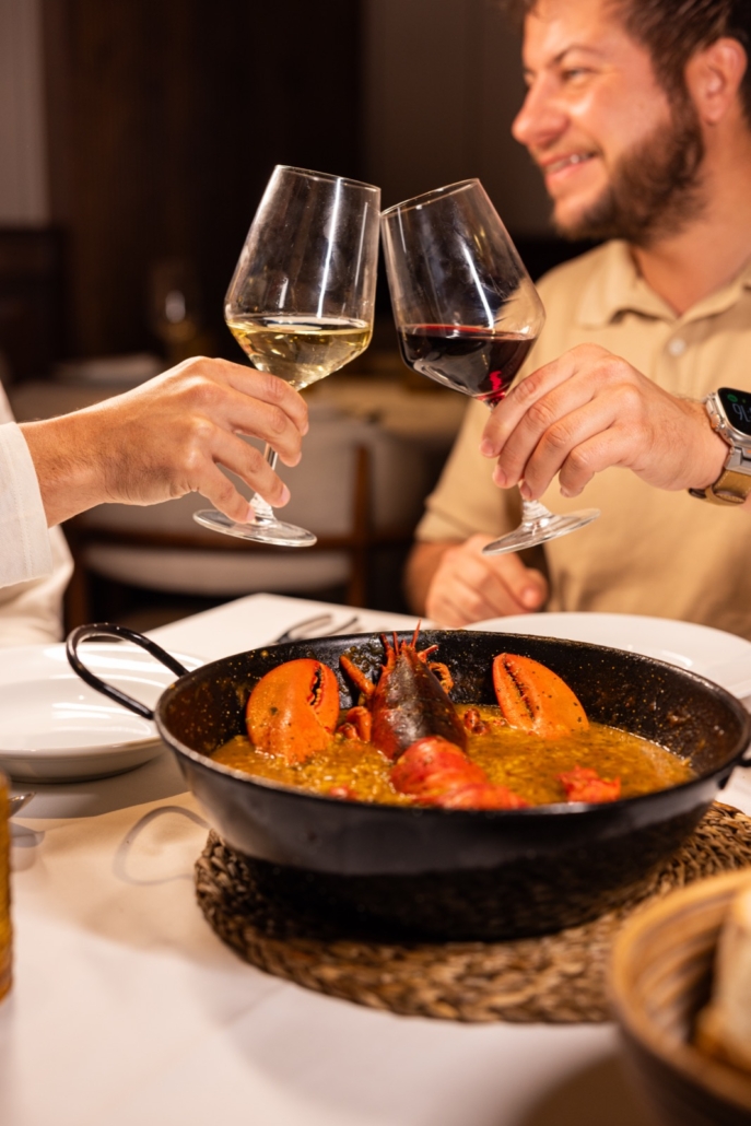 Brindis sobre un arroz de bogavante para compartir en La Taberna de Peñalver, restaurante para grupos en Madrid